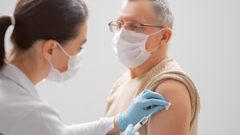 doctor giving a senior man a vaccination STNBNYD