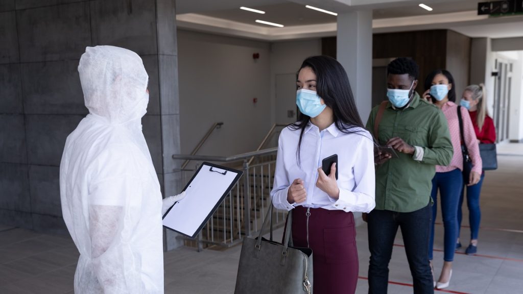 group of people wearing face masks standing in que KR9FY5M