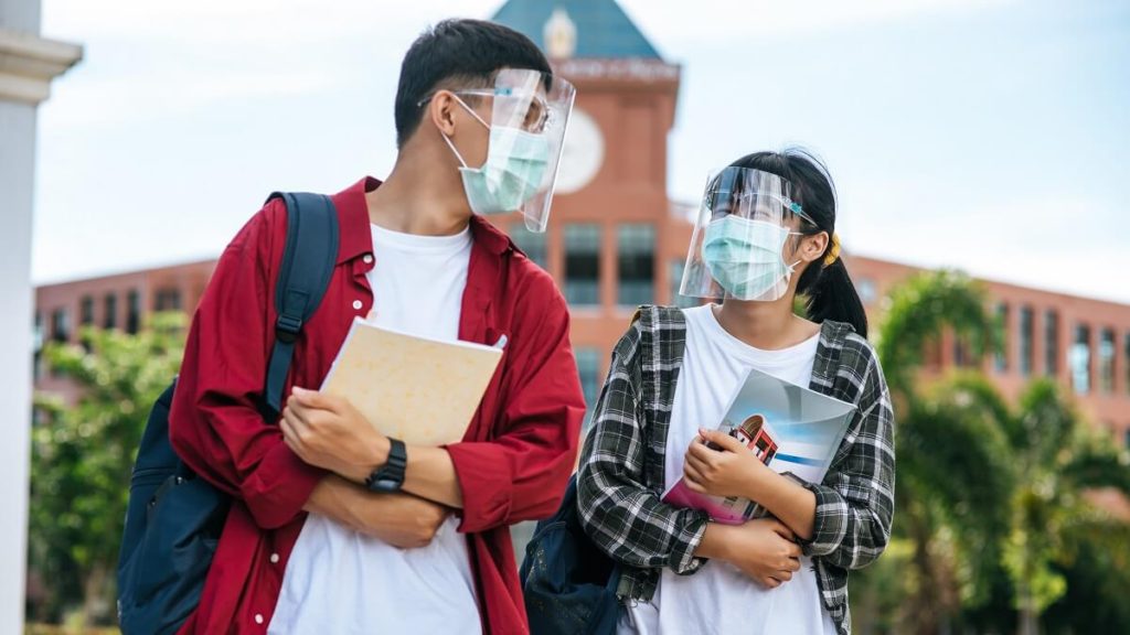 male female students wear masks stand front university 1