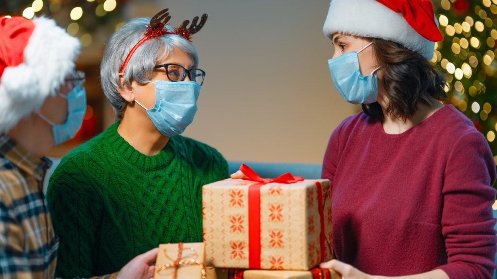 people with gifts wearing facemasks on christmas NP774VV