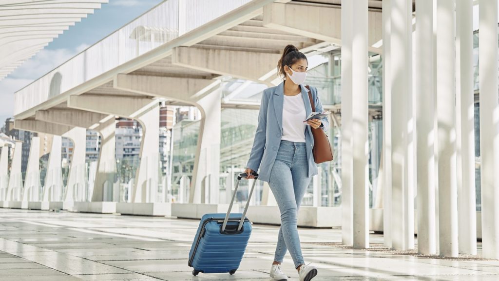 woman with luggage during pandemic airport