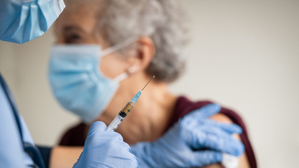 doctor makes vaccination to senior woman with surg UKQJRM7