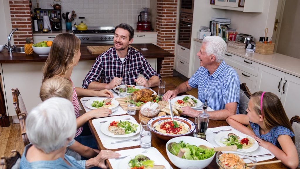 multi generation family talking while having meal kitchen