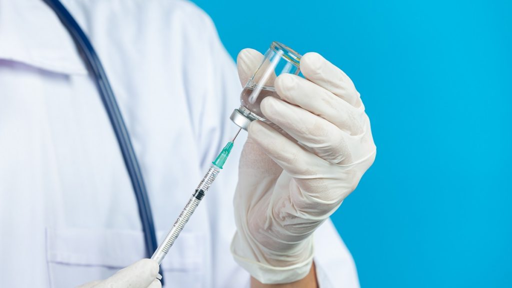 close up picture docter s hands holding hypodermic syringe