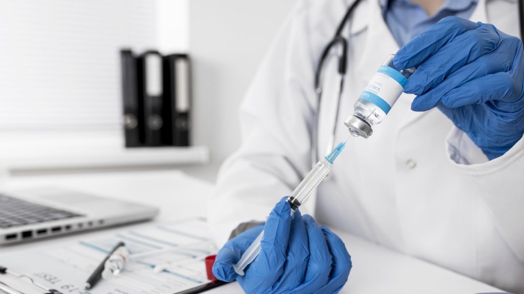 close up doctor holding medical syringe