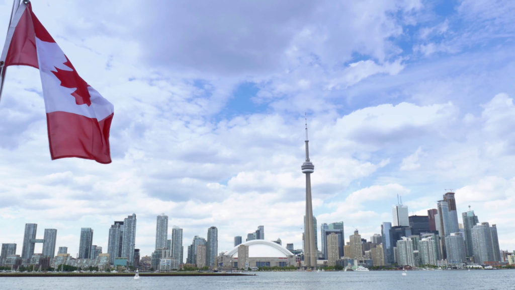 4k toronto skyline from lake ontario with cn tower and canadian flag xjnpl9mu F0000 copy