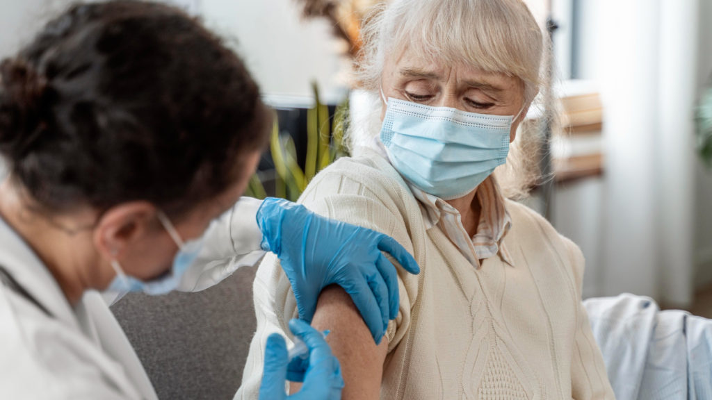 doctor vaccinating senior woman copy