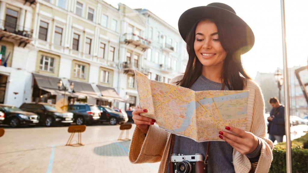 portrait smiling woman tourist holding city map copy