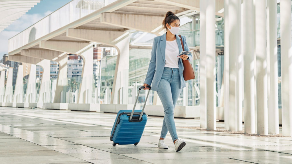 woman with luggage during pandemic airport copy