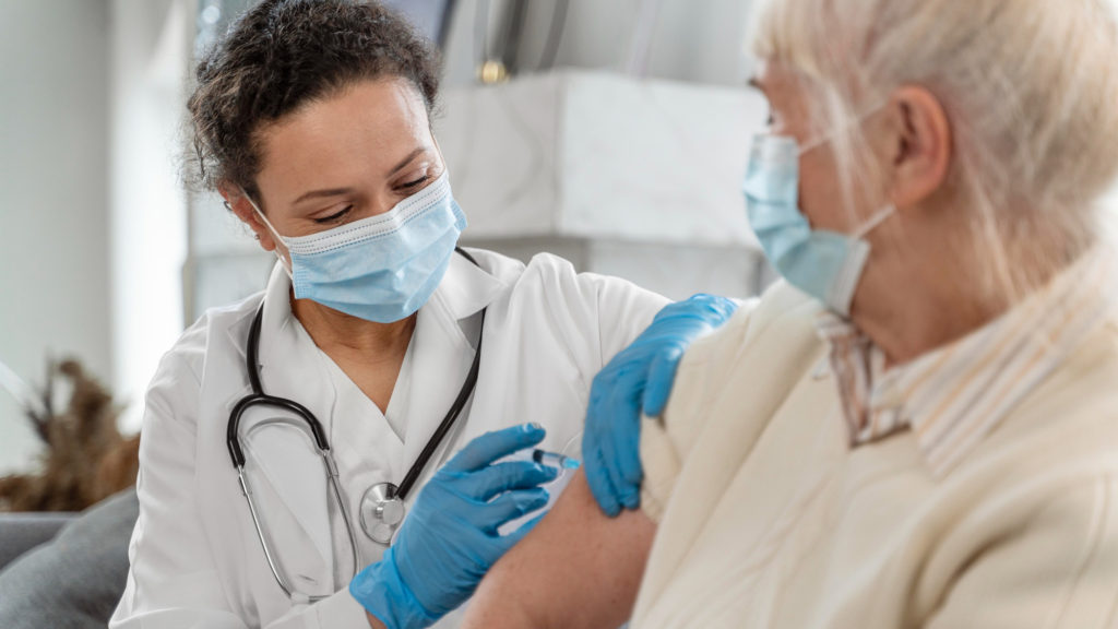 doctor vaccinating senior woman copy