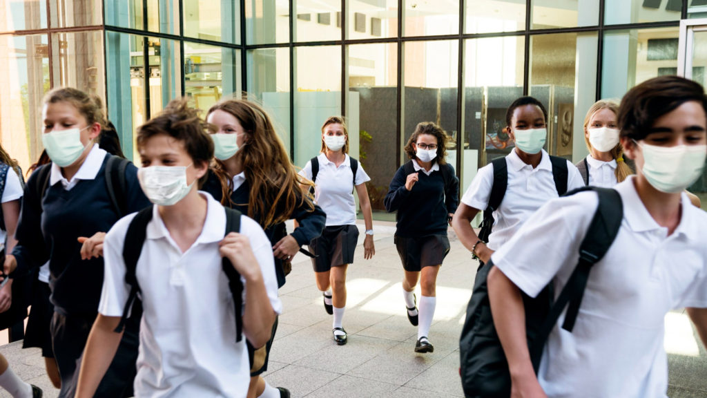 high school students wearing masks their way home copy