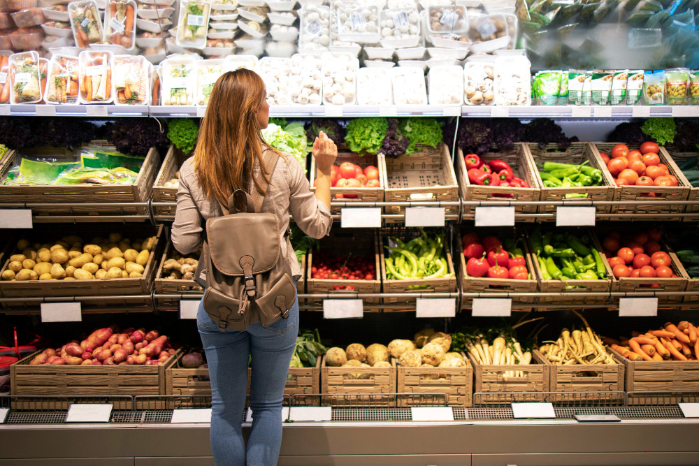 good looking woman standing front vegetable shelves choosing what buy 1 copy