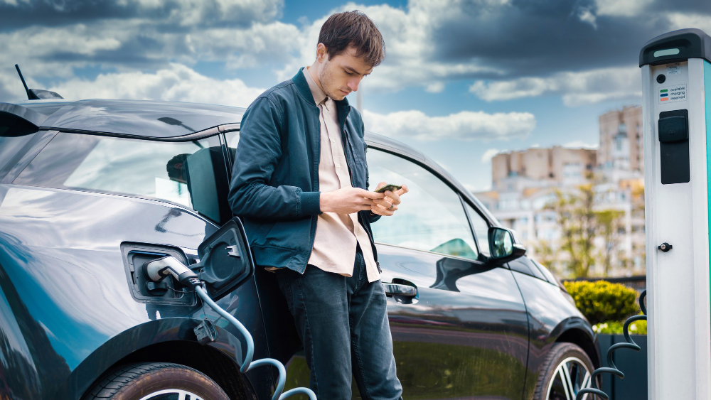 man charging his electric car charge station using smartphone