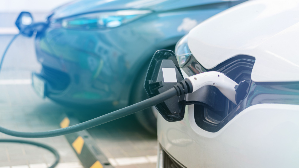 plugged chargers into two electric cars charge station