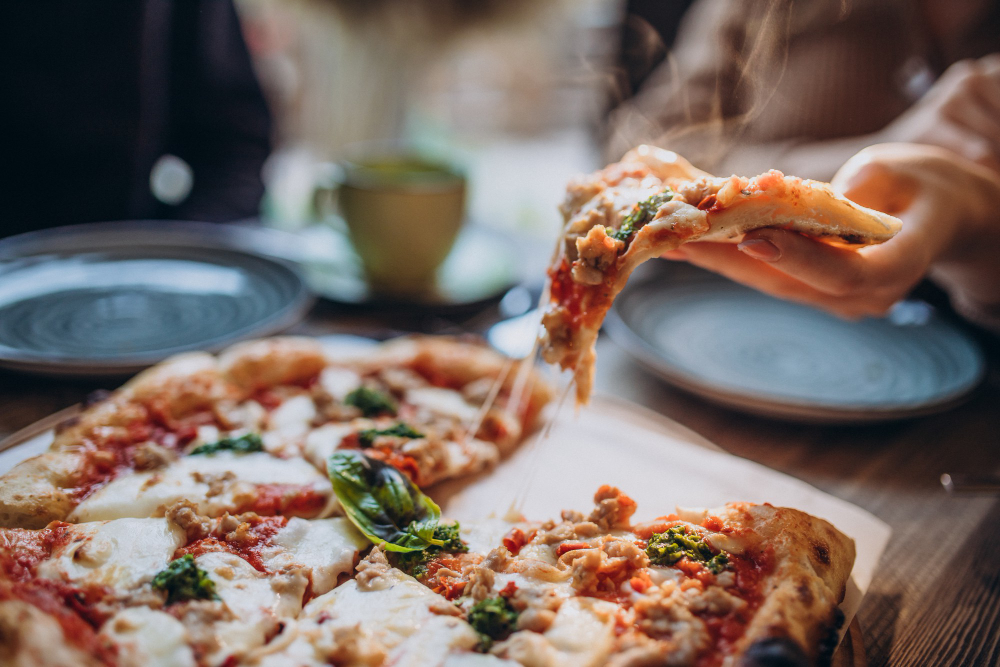 three firends together eating pizza cafe