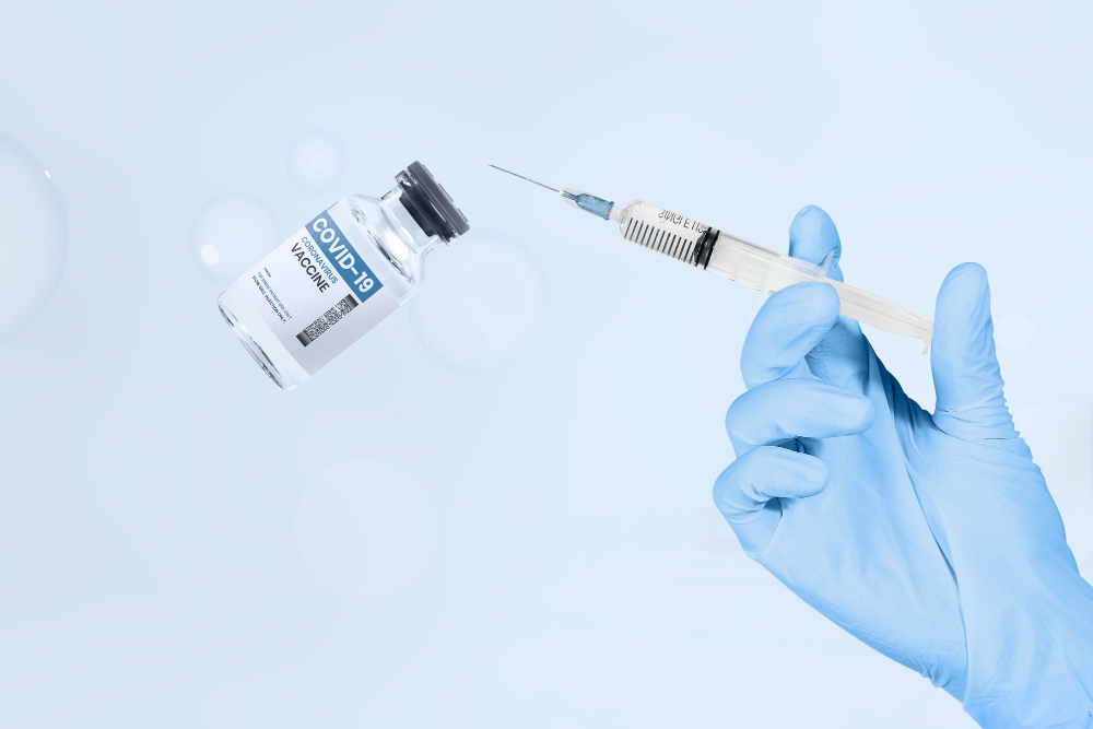 hand holding syringe vaccine vial