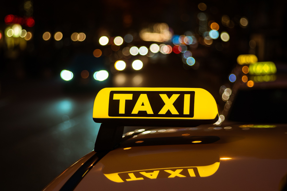 yellow black sign taxi placed top car night