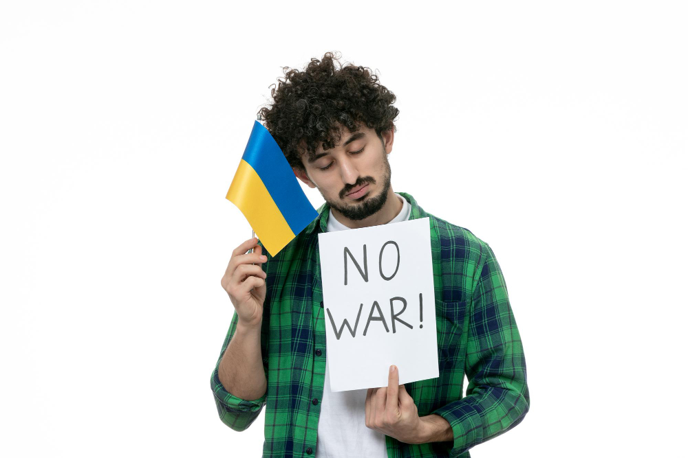 ukraine russian conflict cute guy green shirt holding no war sign ukrainian flag