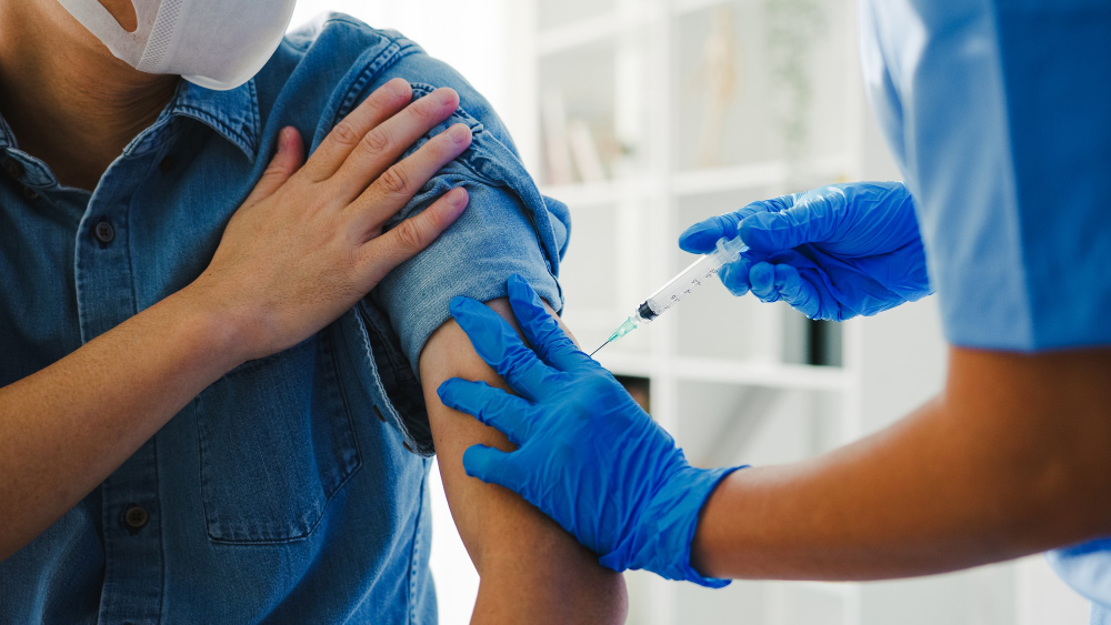 young asian lady nurse giving covid 19 flu antivirus vaccine shot senior male patient